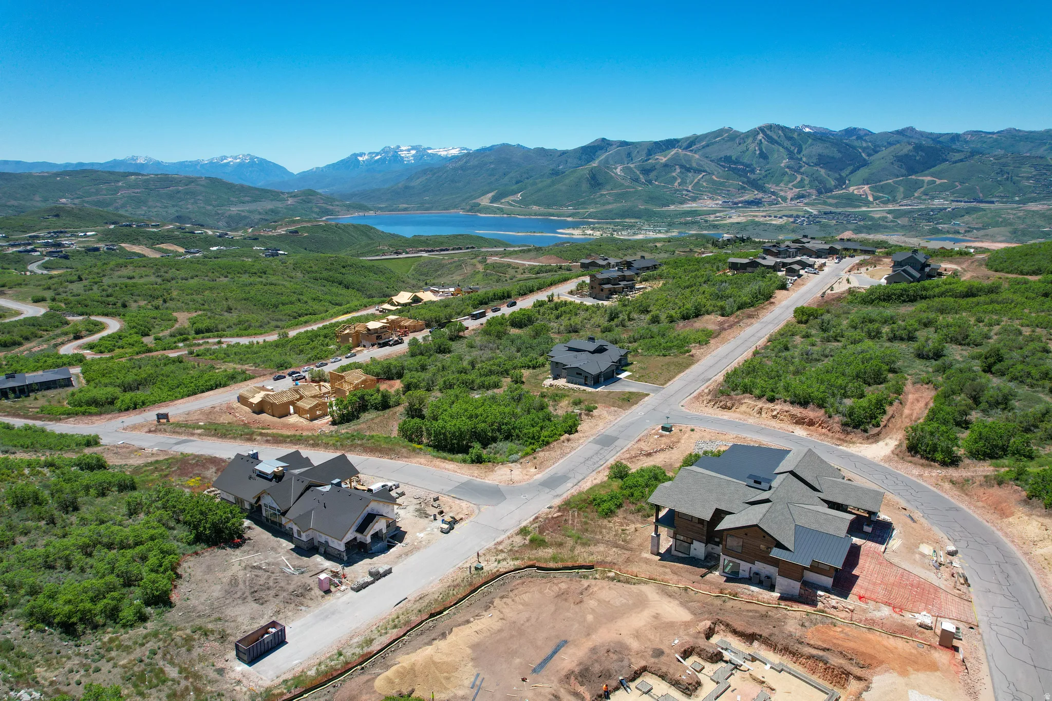 Aerial perspective showcasing multiple properties under development amidst mountainous terrain