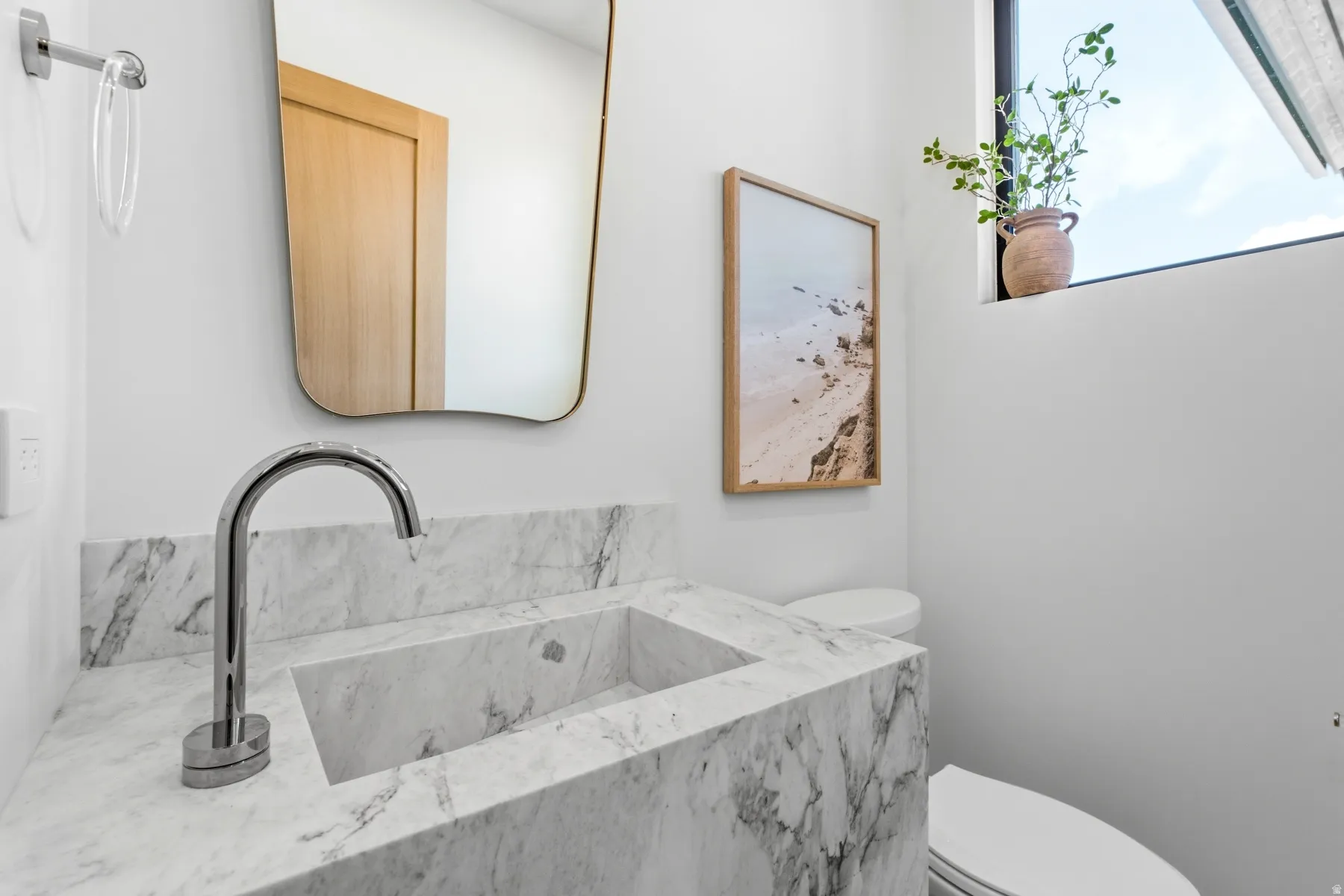 Integrated white marble vanity with a rectangular basin and a polished chrome faucet