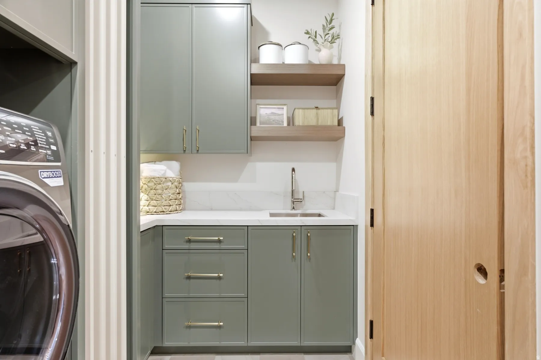 Corner utility sink with a brushed nickel faucet, set within a white countertop