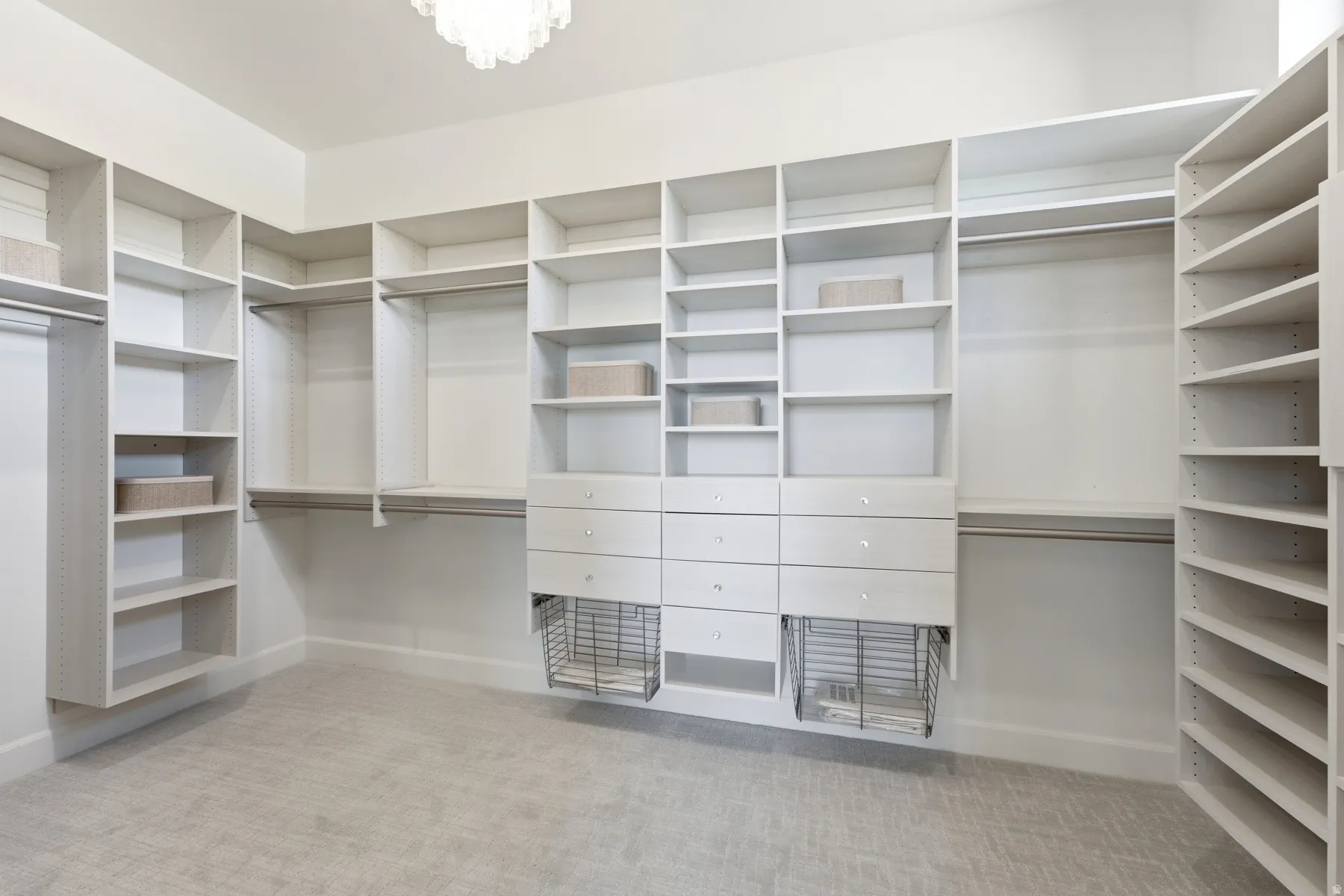 Custom closet system featuring extensive shelving, multiple hanging rods, built-in drawers, and integrated wire baskets