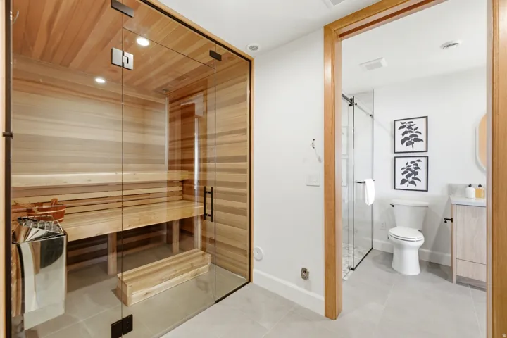 Glass-enclosed sauna with wood-paneled interior and built-in benches