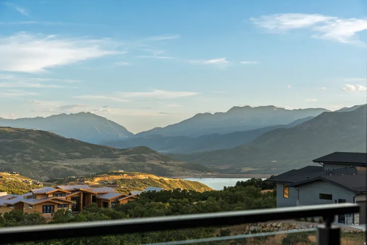 Balcony with glass railing overlooking mountainous scenery and a body of water