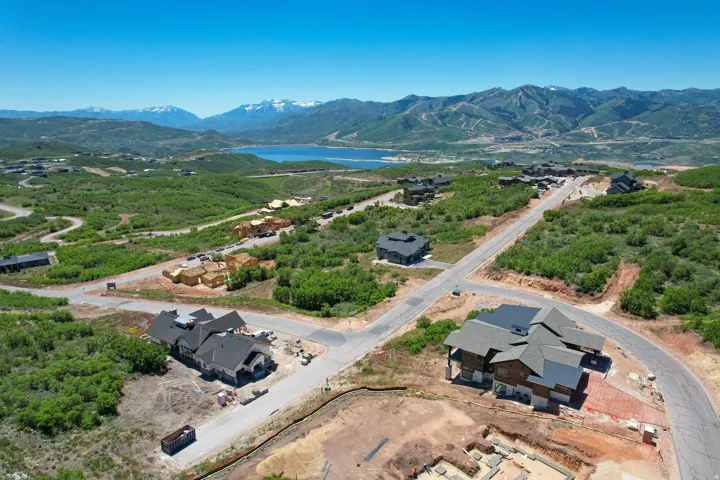 Aerial perspective showcasing multiple properties under development amidst mountainous terrain