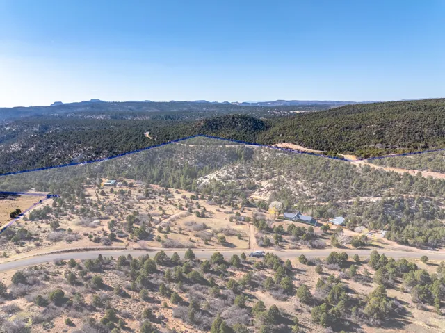 Aerial view of property and surrounding area featuring property parcel outlined and a mountain backdrop