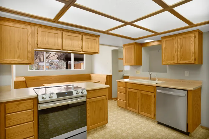 Kitchen with appliances with stainless steel finishes, light countertops, and light floors