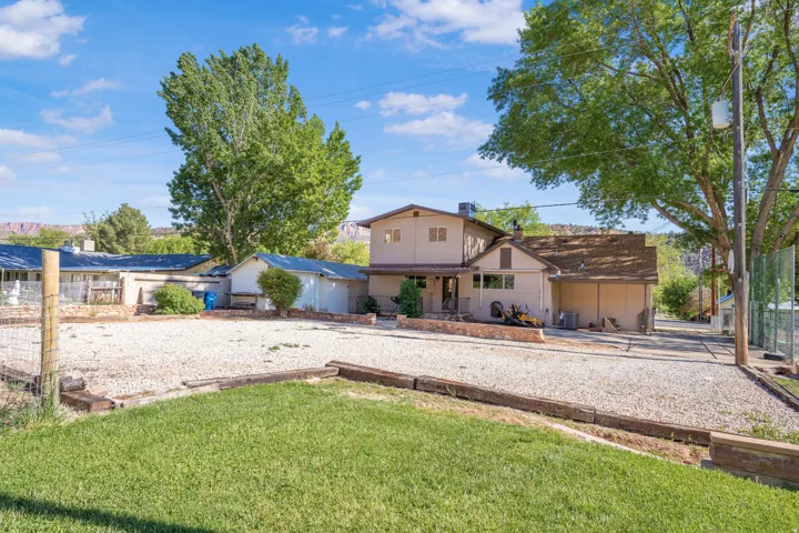 Back of property with a chimney and stucco siding