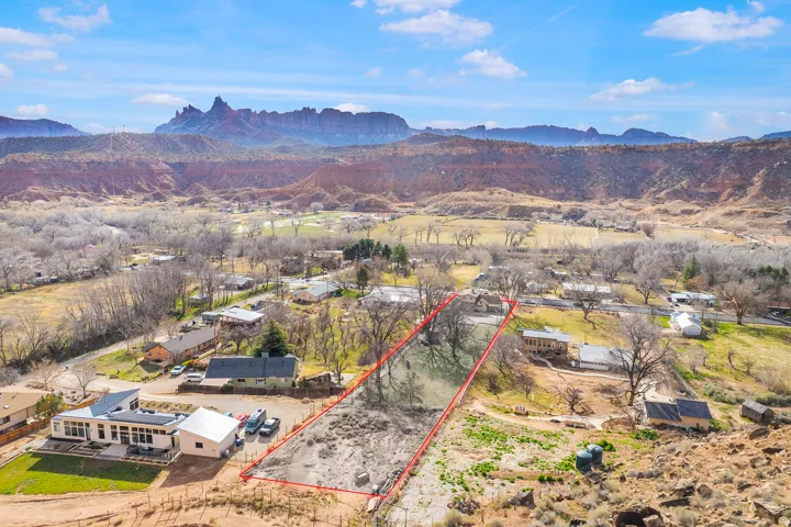 Aerial view of property and surrounding area with property boundaries highlighted and mountains
