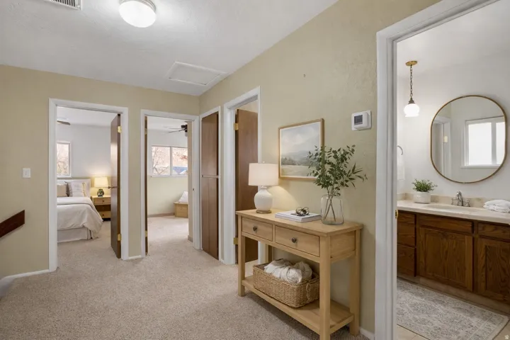 Corridor featuring attic access and light colored carpet