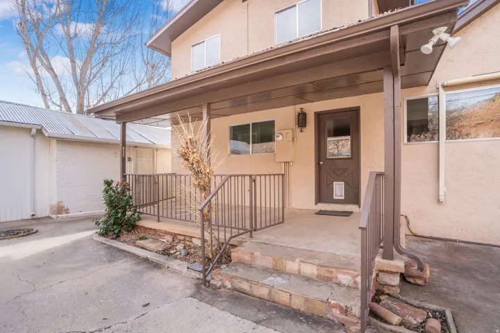Doorway to property with stucco siding and covered porch