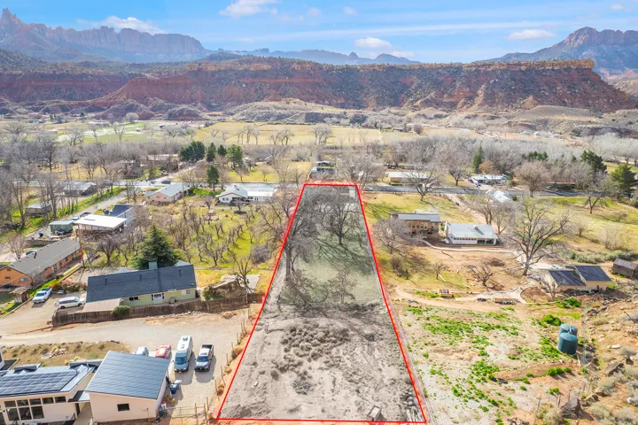 Aerial view of property's location featuring a mountainous background and property parcel outlined