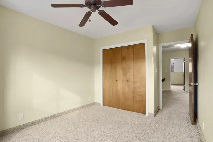 Unfurnished bedroom featuring carpet flooring, a closet, and ceiling fan