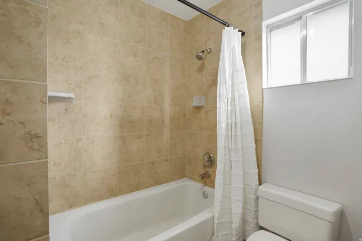 Full bathroom with shower / bath combo and toilet