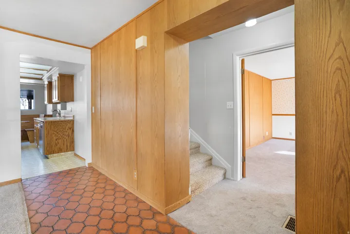 Hallway featuring tile patterned floors and carpet flooring
