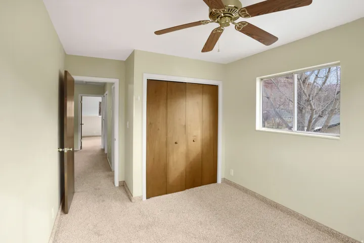 Unfurnished bedroom with carpet flooring, a closet, and a ceiling fan