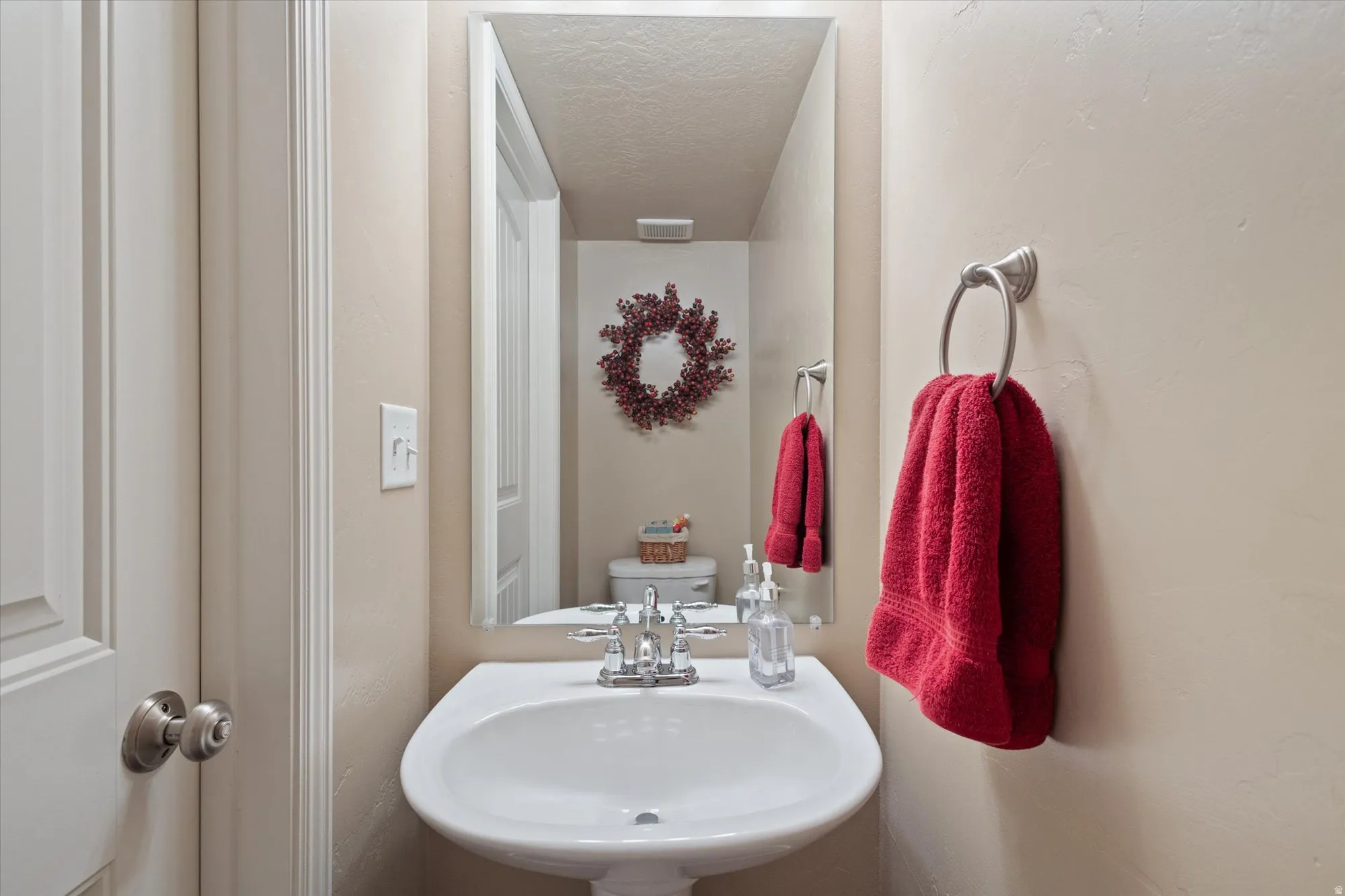 Half bathroom with a sink and a textured ceiling