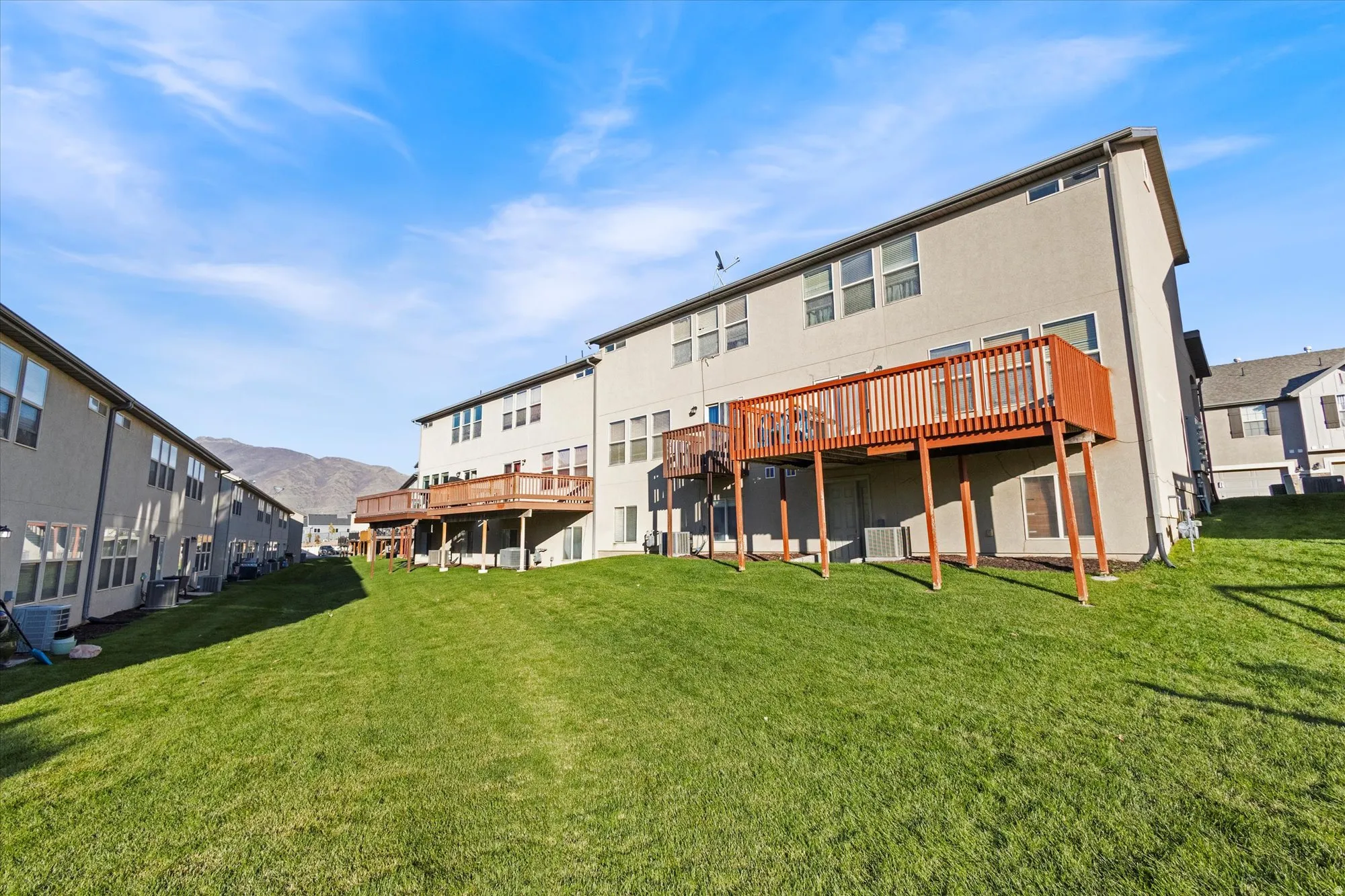 Rear view of house with a deck with mountain view and a yard