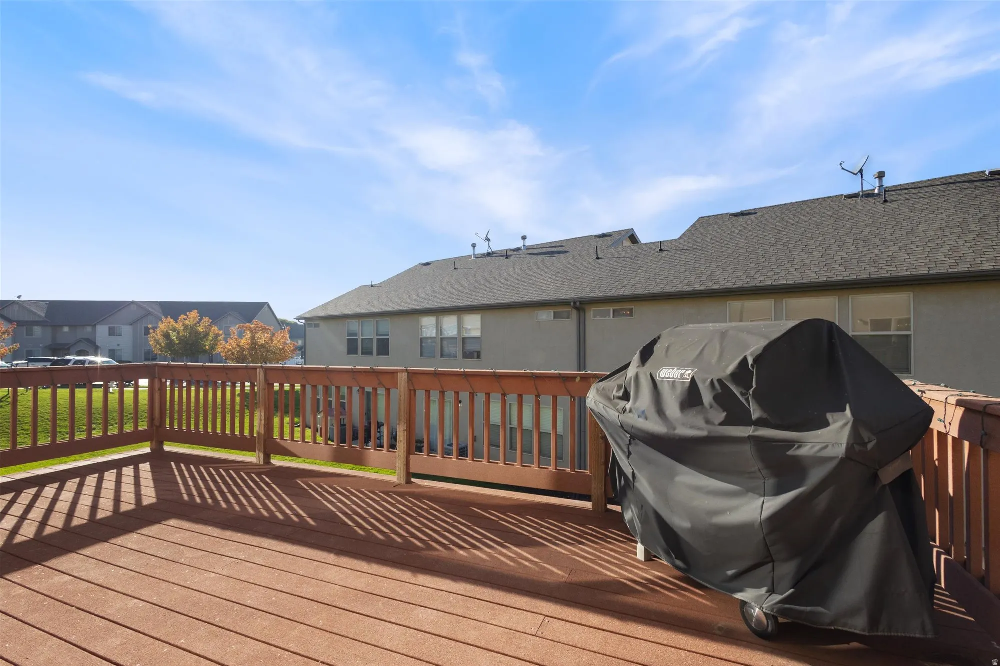 Wooden deck featuring area for grilling and a residential view