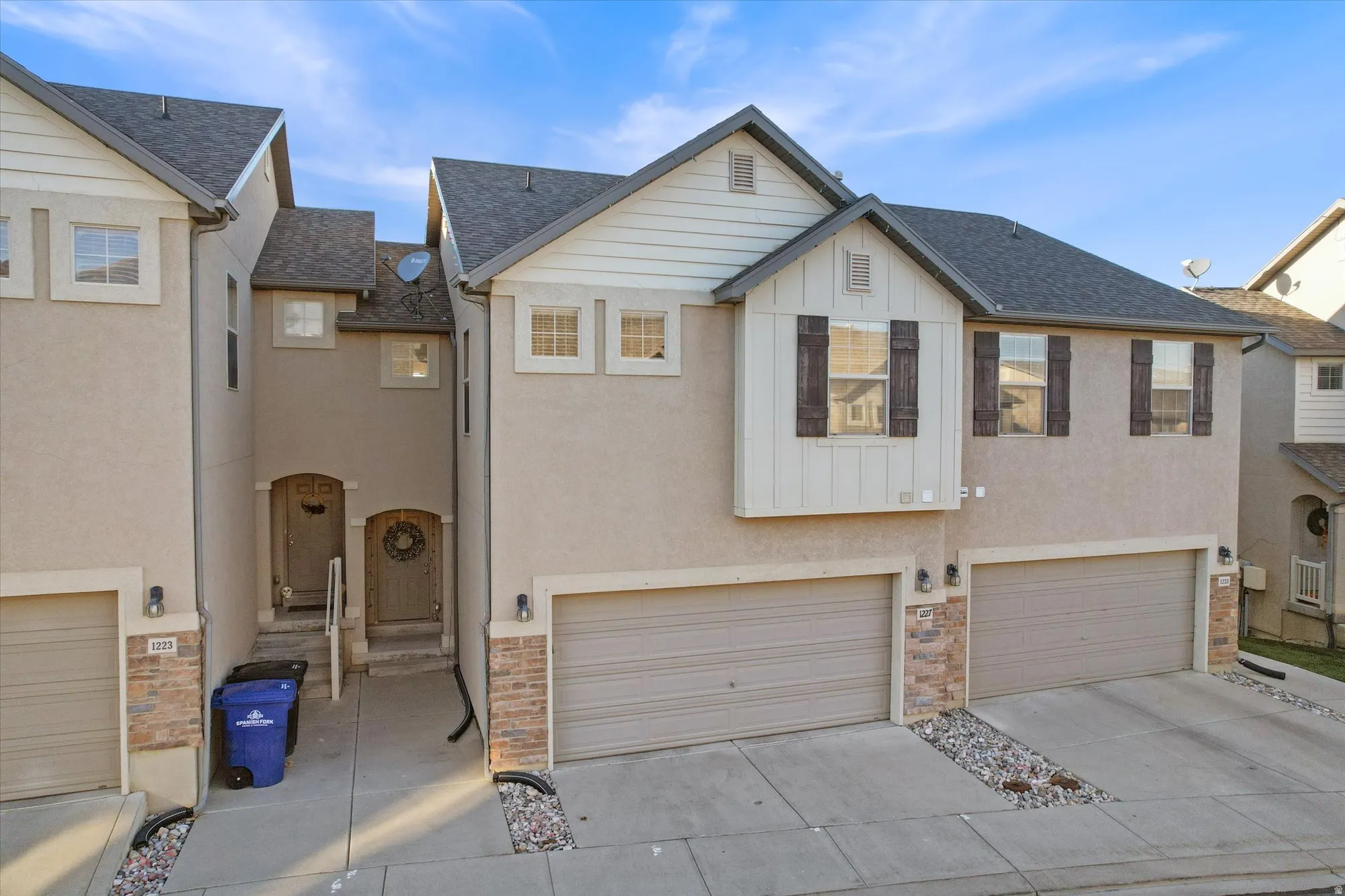 View of front of home featuring roof with shingles, board and batten siding, driveway, and an attached garage