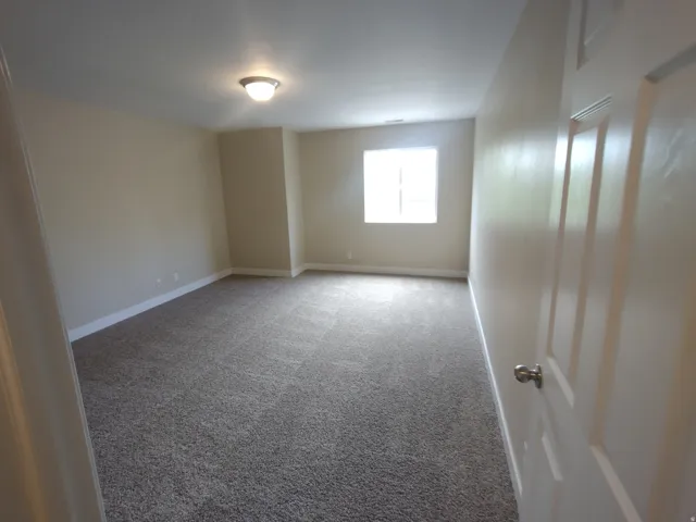 Empty room featuring carpet floors and baseboards