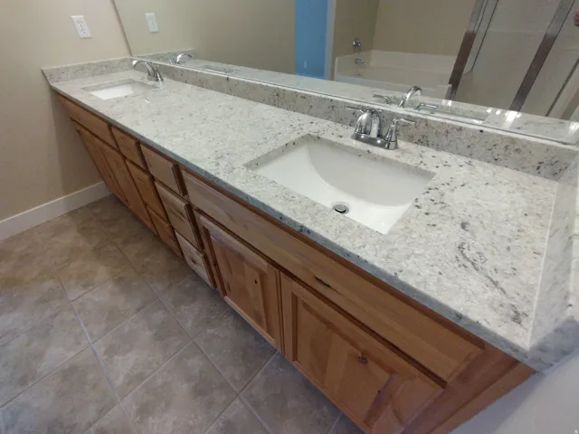 Full bath featuring light tile patterned floors, double vanity, and a garden tub