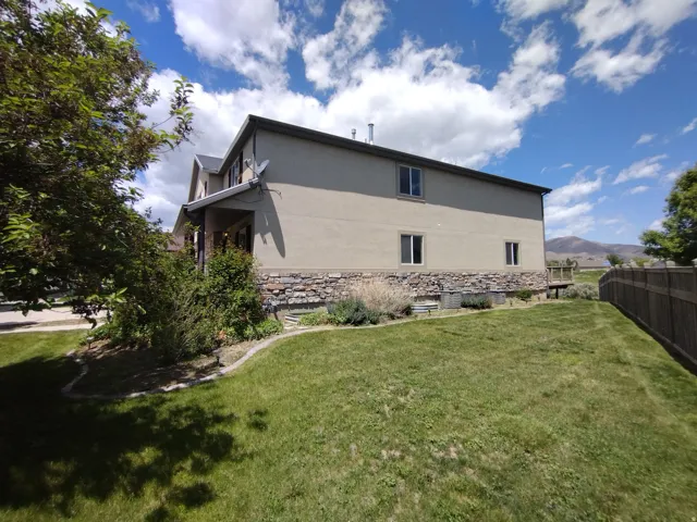View of side of property with stucco siding, stone siding, and a mountain view