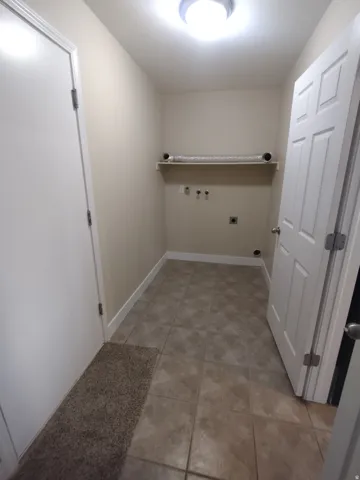Washroom with washer hookup, light tile patterned floors, hookup for an electric dryer, and gas dryer hookup