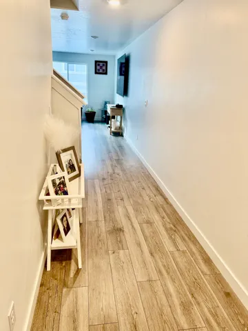 Hall with baseboards and light wood-style flooring