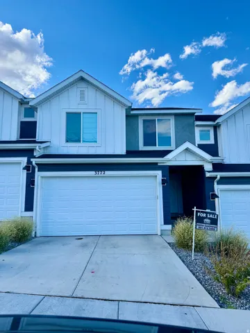 Traditional home featuring driveway, board and batten siding, and a garage