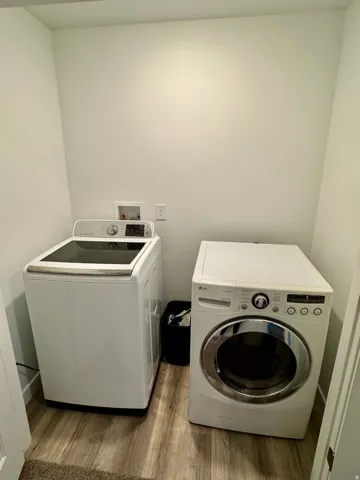 Washroom featuring light wood-style flooring and independent washer and dryer