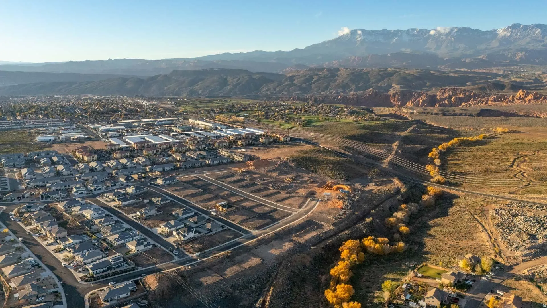 Aerial view of property and surrounding area with a mountain backdrop and nearby suburban area