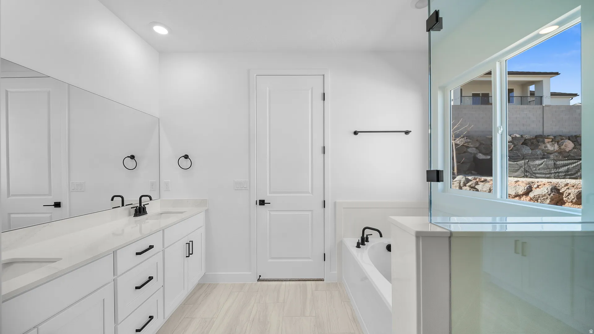 Full bathroom with double vanity, a bath, and recessed lighting