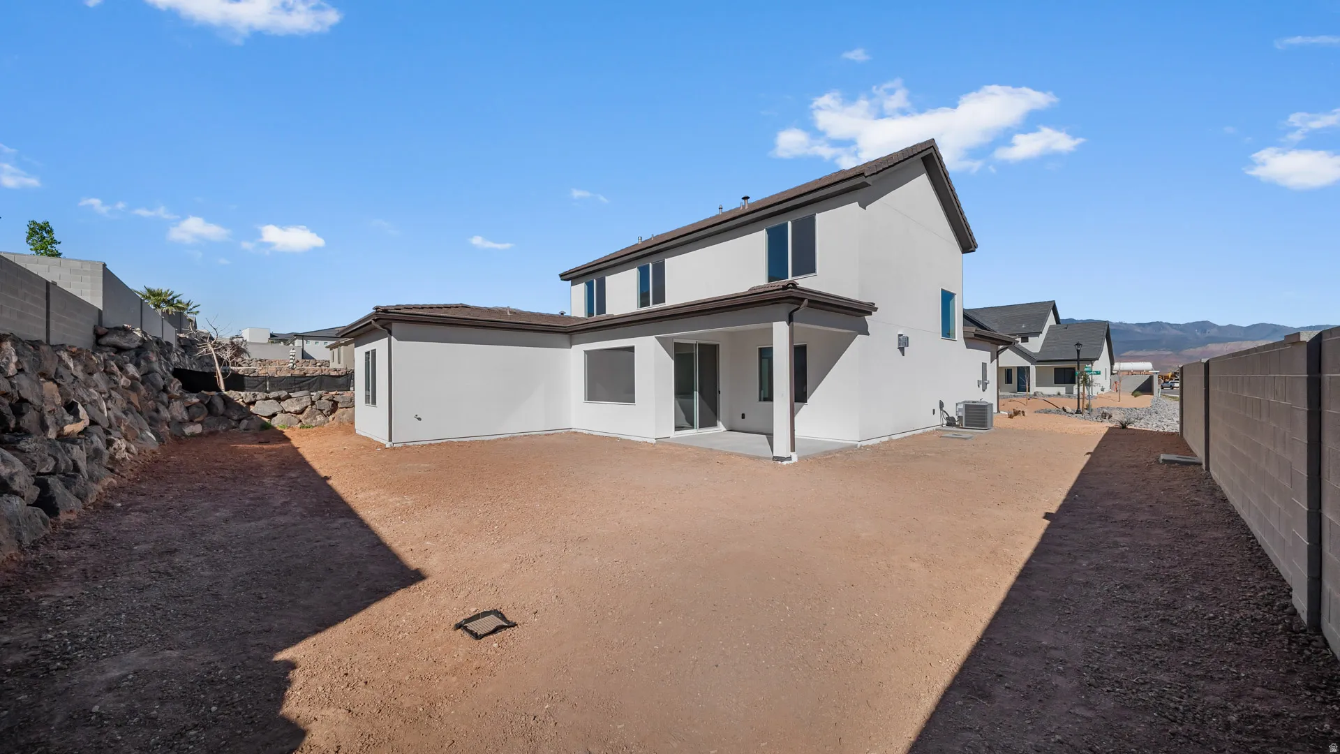 Rear view of property featuring a patio area, stucco siding, and a fenced backyard