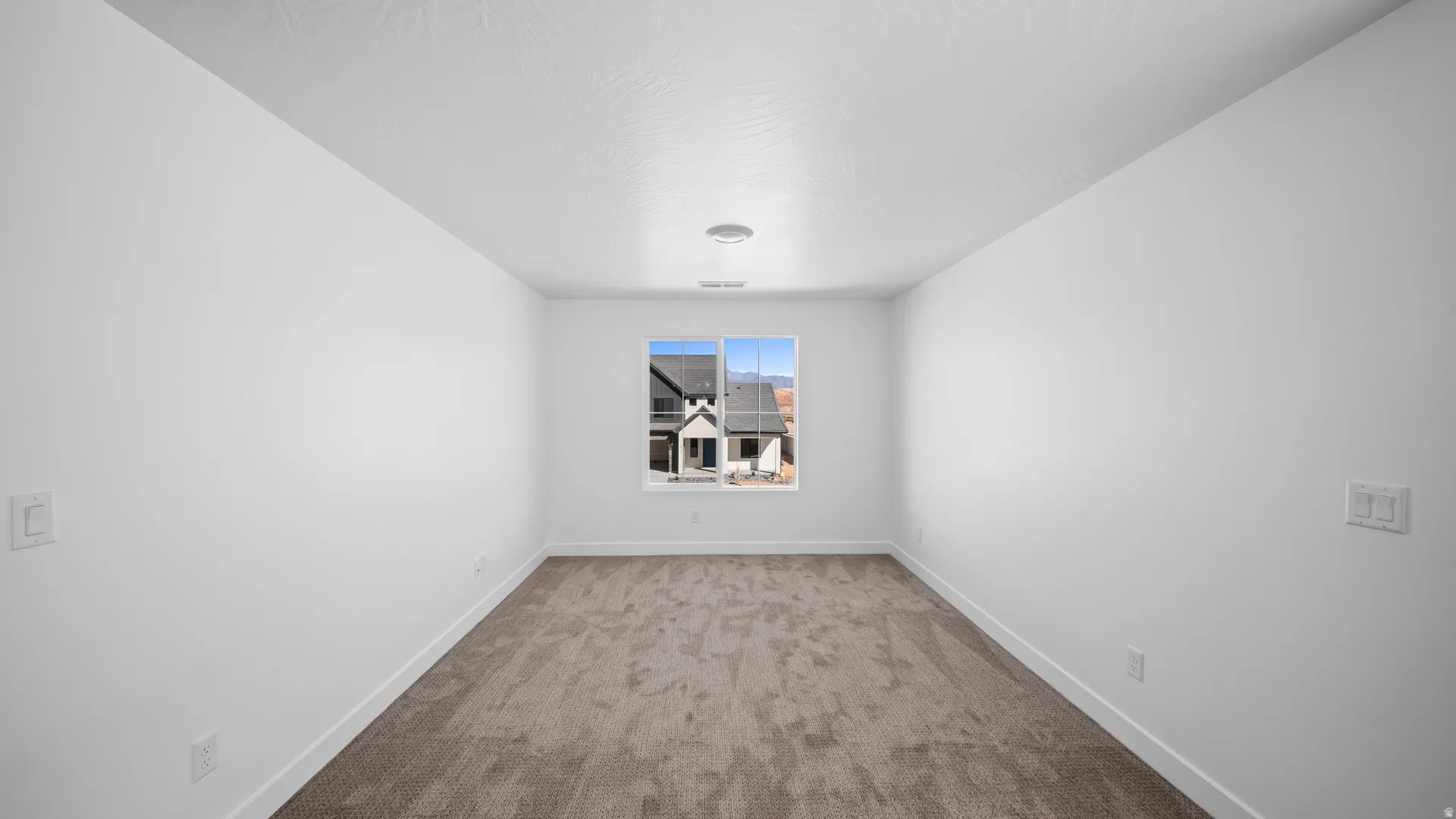 Carpeted spare room with baseboards