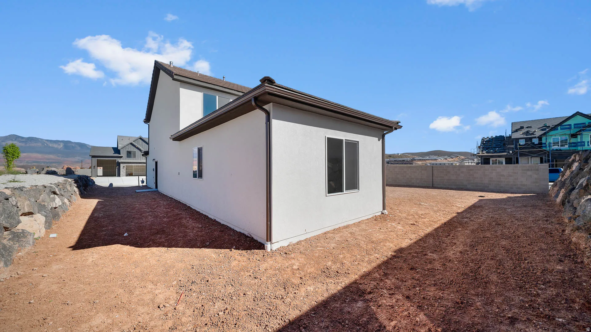 View of property exterior with a fenced backyard, a mountain view, and stucco siding