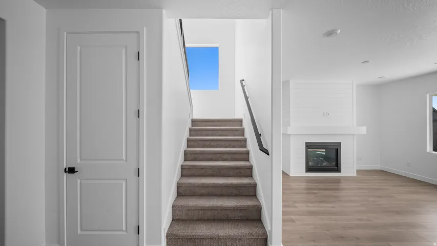 Stairs featuring a fireplace and wood finished floors