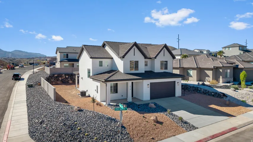 View of front of home featuring a residential view, a garage, concrete driveway, and stucco siding