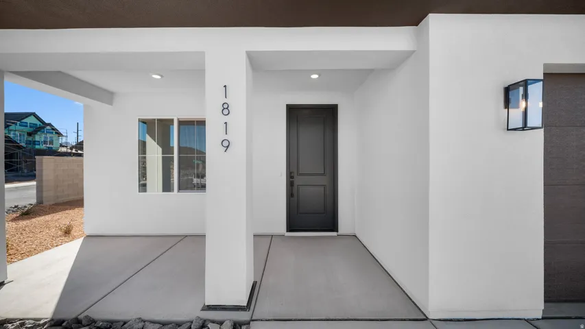 Property entrance featuring a porch and stucco siding