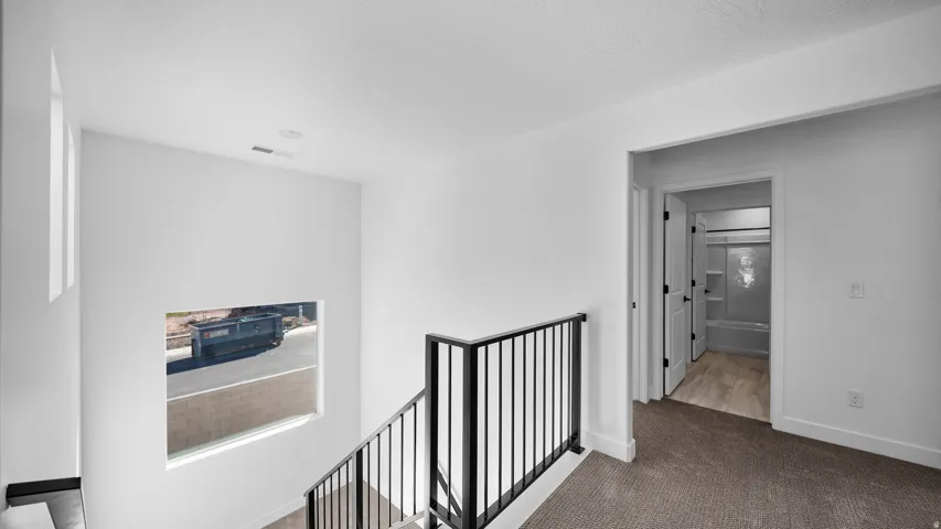 Hall featuring carpet and an upstairs landing
