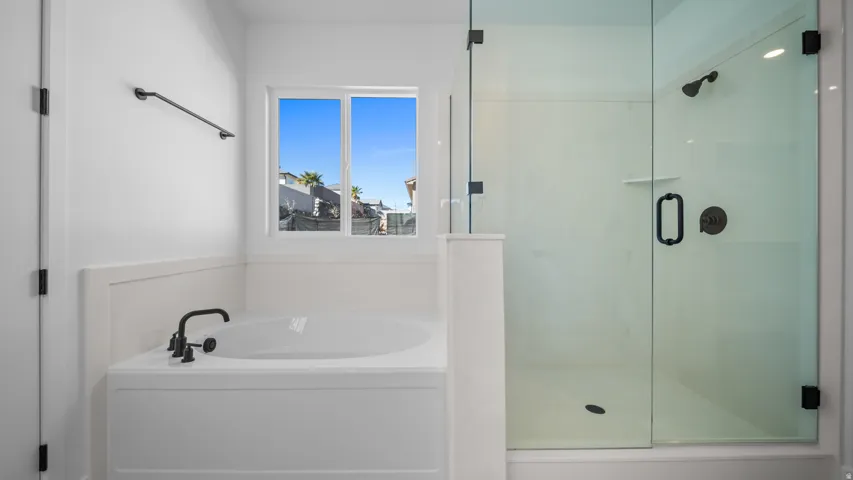 Bathroom with a stall shower and a bath