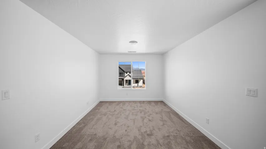 Carpeted spare room with baseboards