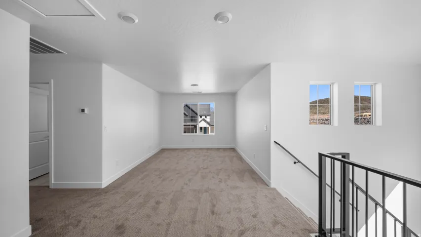 Empty room featuring light colored carpet and baseboards