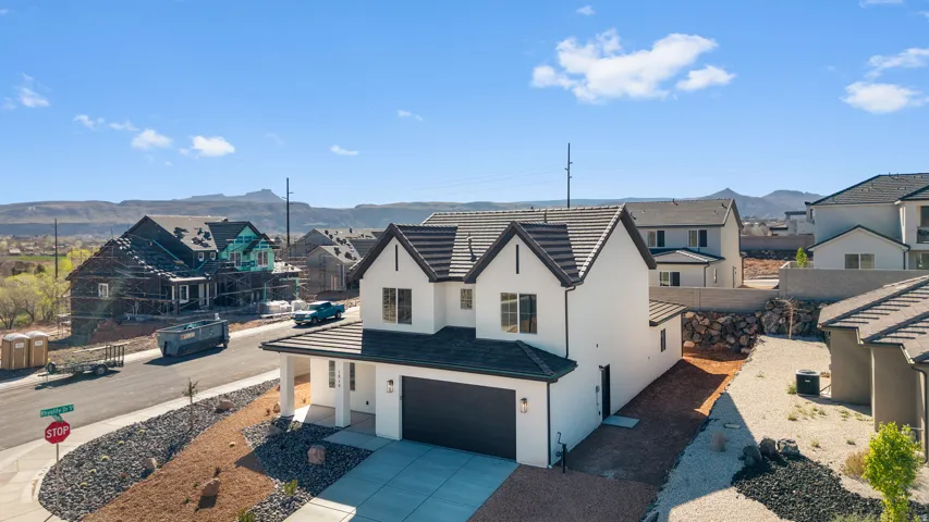 View of front facade featuring a residential view, stucco siding, concrete driveway, a garage, and a mountain view