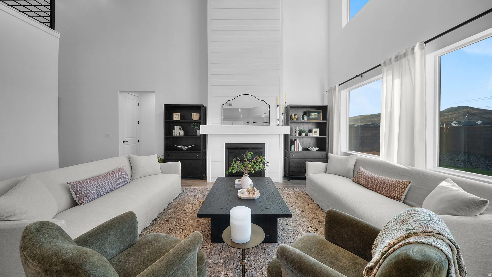 Living room with a high ceiling, a fireplace, and wood finished floors