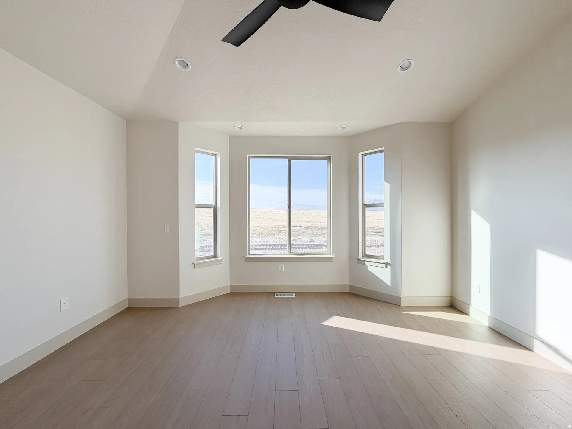 Spare room with light wood finished floors, a ceiling fan, and recessed lighting