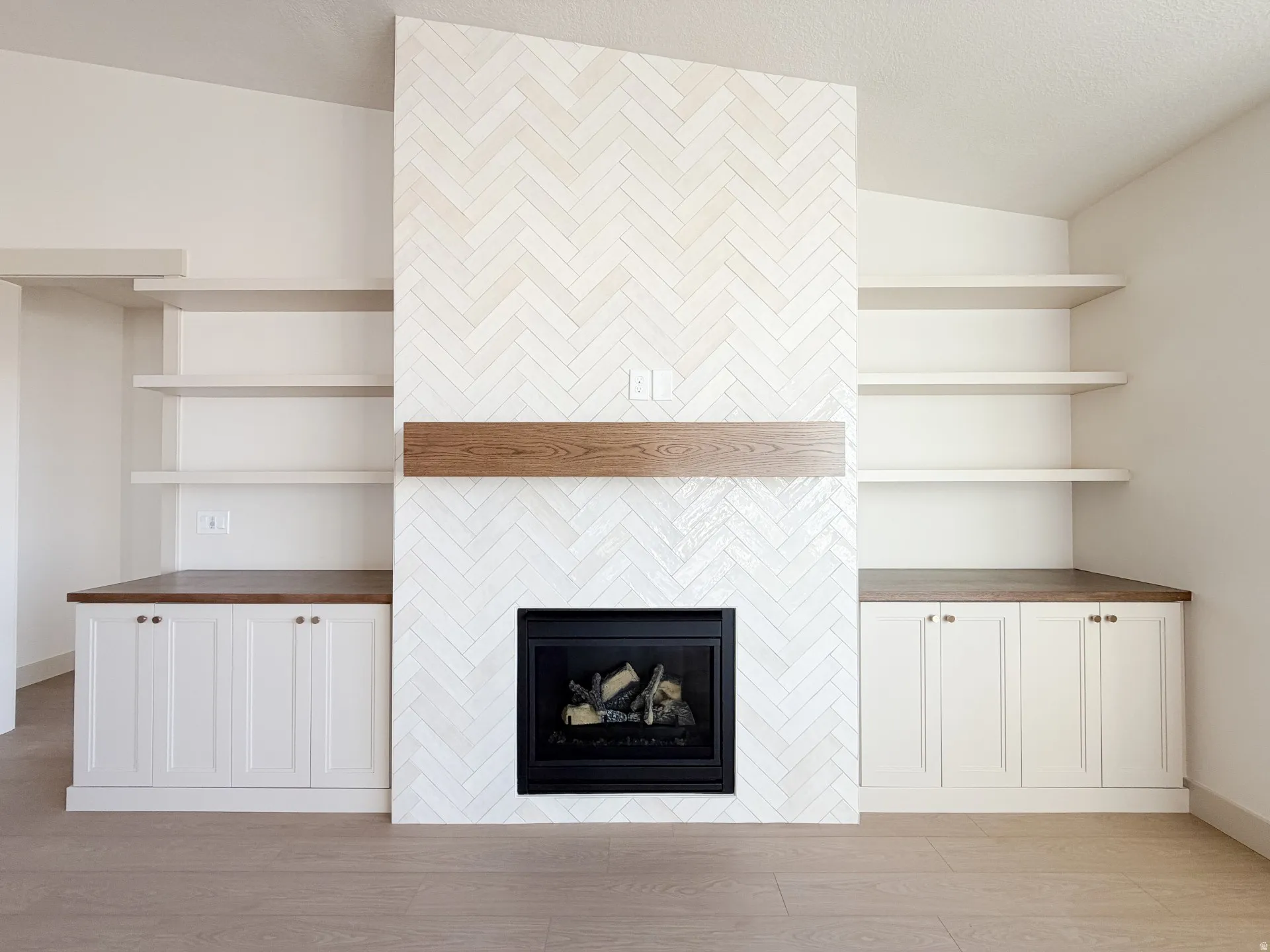 Detailed view of wood finished floors and a tile fireplace