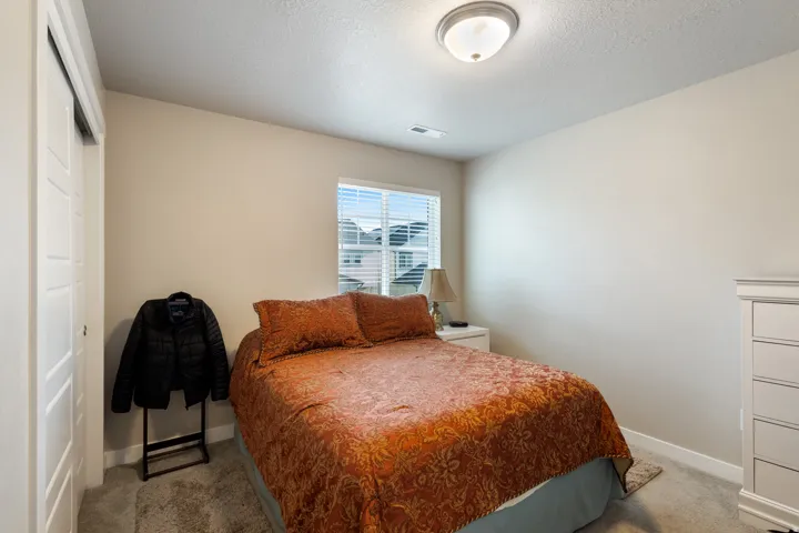 Bedroom featuring carpet floors, a textured ceiling, and a closet