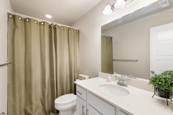 Full bathroom with vanity and curtained shower