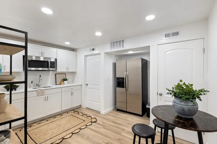Kitchen with stainless steel appliances, white cabinets, light wood finished floors, and recessed lighting