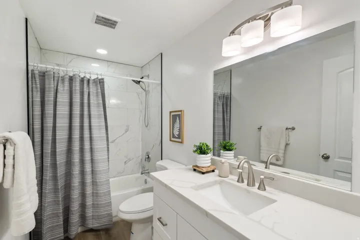 Bathroom with shower / bath combination with curtain, vanity, and dark wood-style floors