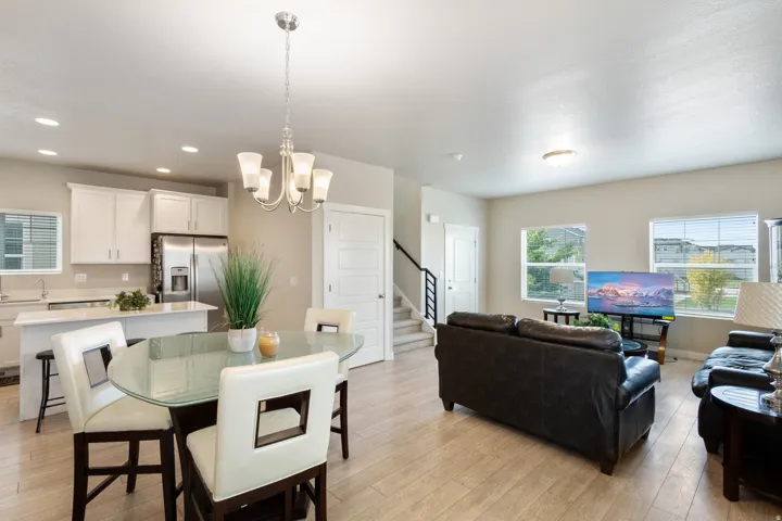 Dining room featuring light wood finished floors, stairs, a chandelier, and recessed lighting